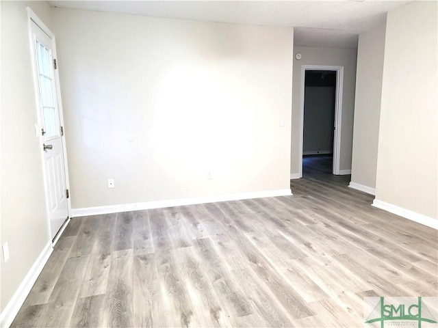 unfurnished room featuring light wood-style floors and baseboards