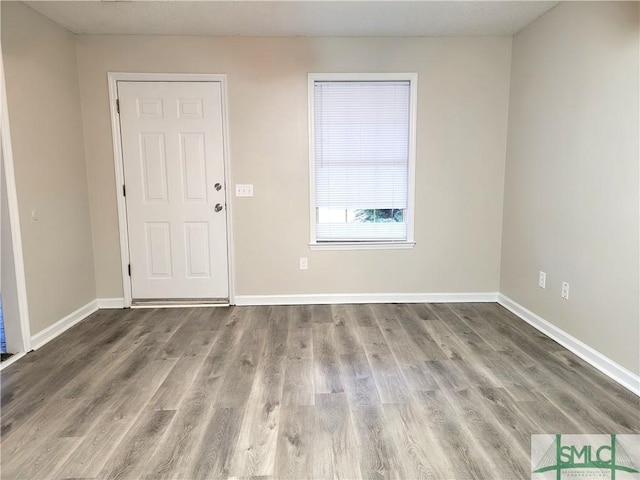 interior space featuring baseboards and wood finished floors