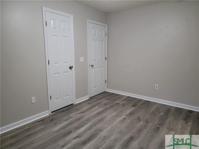 unfurnished bedroom with baseboards and wood finished floors