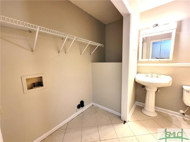 laundry area with hookup for a washing machine, baseboards, and light tile patterned flooring