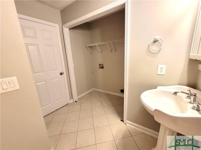 bathroom with baseboards, a sink, and tile patterned floors