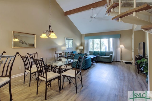 dining room with wood-type flooring, ceiling fan with notable chandelier, high vaulted ceiling, and beam ceiling