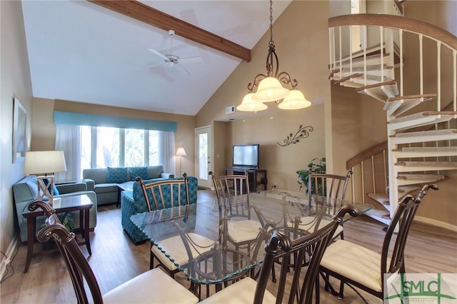 dining area featuring beamed ceiling, hardwood / wood-style floors, ceiling fan with notable chandelier, and high vaulted ceiling