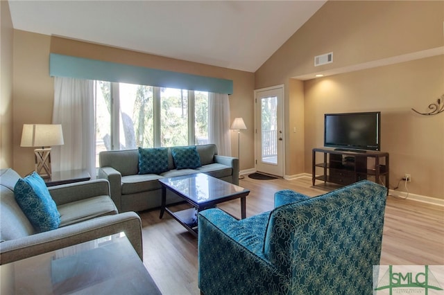 living room with high vaulted ceiling and hardwood / wood-style flooring