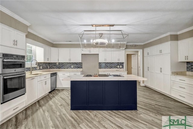 kitchen featuring pendant lighting, sink, white cabinets, and appliances with stainless steel finishes