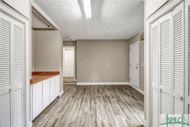 unfurnished bedroom with a textured ceiling and light wood-type flooring