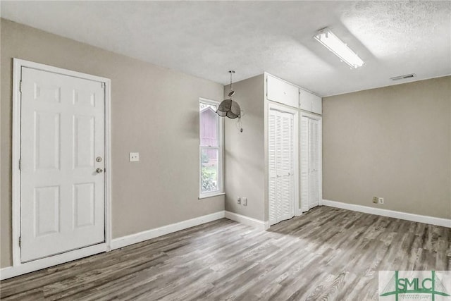 interior space featuring hardwood / wood-style floors, a closet, and a textured ceiling