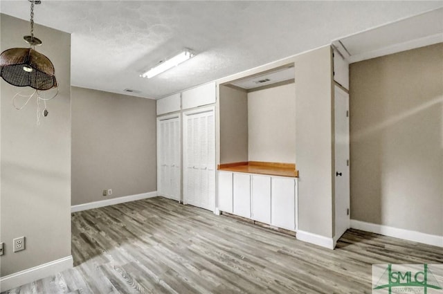 unfurnished bedroom with light hardwood / wood-style flooring and a closet