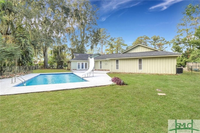 rear view of property featuring a fenced in pool, a yard, and a patio