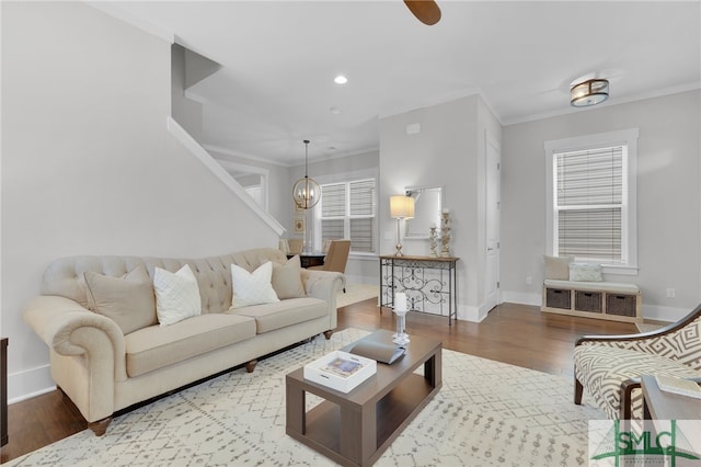 living room featuring ornamental molding, a chandelier, and hardwood / wood-style flooring