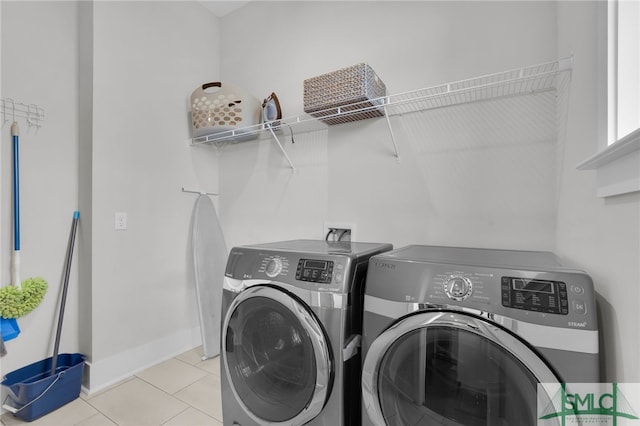 laundry room featuring washing machine and dryer and light tile patterned floors