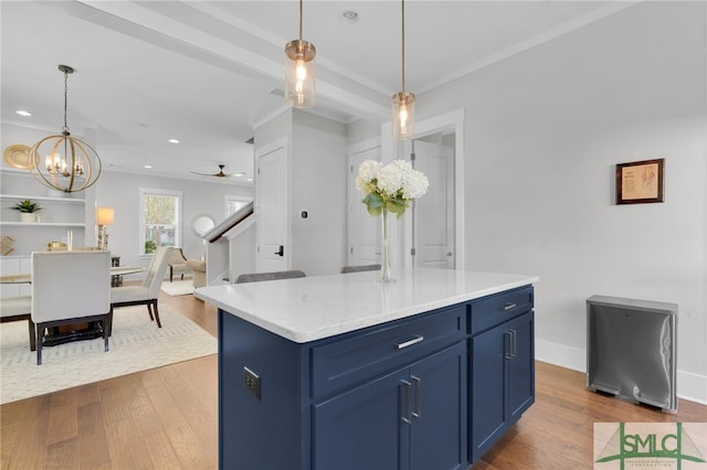 kitchen featuring a center island, blue cabinets, pendant lighting, and hardwood / wood-style flooring