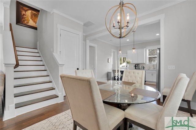 dining area featuring a chandelier, hardwood / wood-style floors, and crown molding