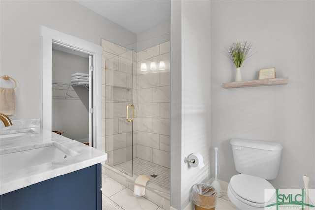 bathroom with tile patterned floors, toilet, vanity, and walk in shower