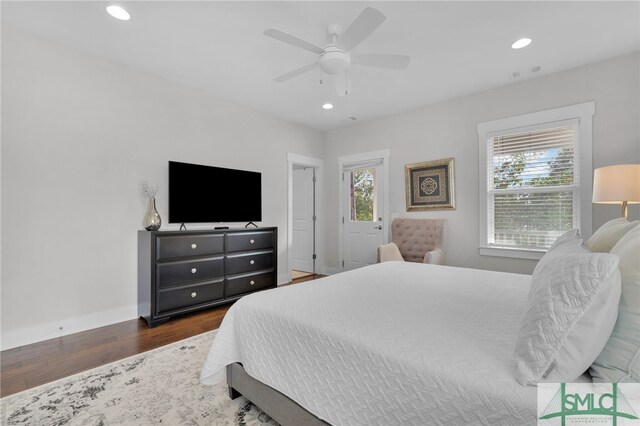 bedroom with multiple windows, ceiling fan, and dark wood-type flooring