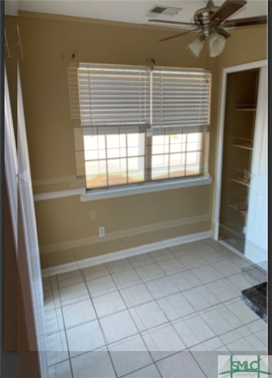 unfurnished bedroom featuring light tile patterned floors, ceiling fan, and ornamental molding