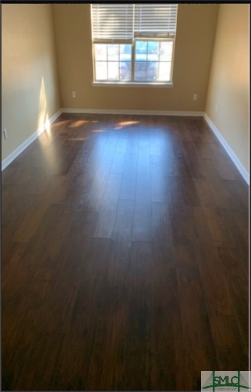 unfurnished room featuring dark wood-type flooring