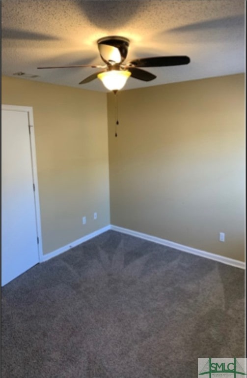 carpeted spare room featuring ceiling fan and a textured ceiling