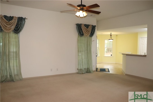 unfurnished living room featuring ceiling fan and light colored carpet