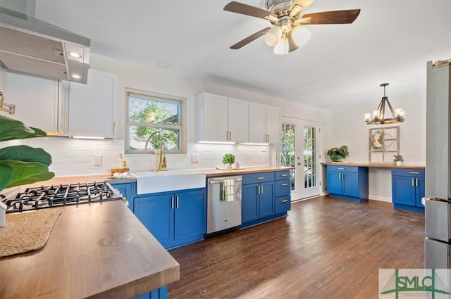 kitchen featuring white cabinets, blue cabinets, hanging light fixtures, a healthy amount of sunlight, and stainless steel appliances