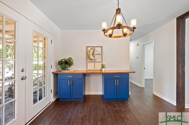 interior space featuring butcher block countertops, dark hardwood / wood-style floors, blue cabinets, and hanging light fixtures