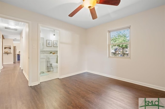 spare room with ceiling fan and dark hardwood / wood-style flooring