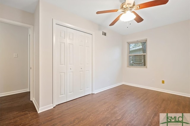 unfurnished bedroom featuring ceiling fan, dark hardwood / wood-style floors, and a closet