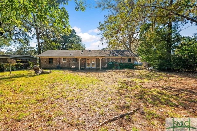 rear view of property with a yard and a carport