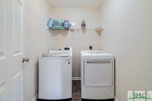 clothes washing area featuring dark hardwood / wood-style flooring, washer and dryer, and a textured ceiling