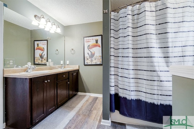 bathroom with vanity, hardwood / wood-style floors, a textured ceiling, and a shower with curtain