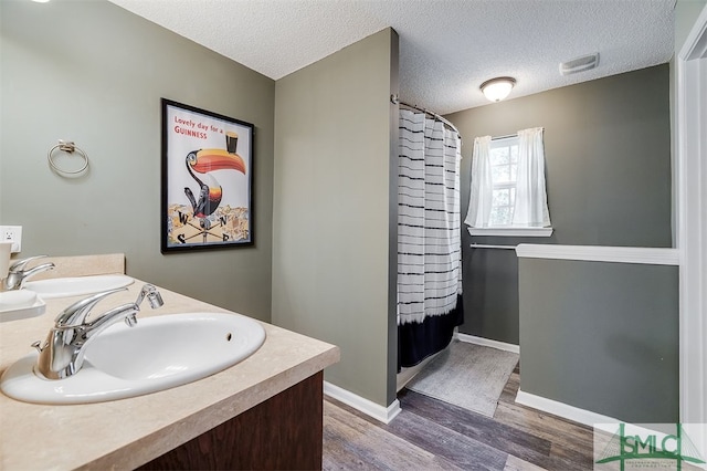 bathroom featuring hardwood / wood-style floors, vanity, a textured ceiling, and a shower with shower curtain