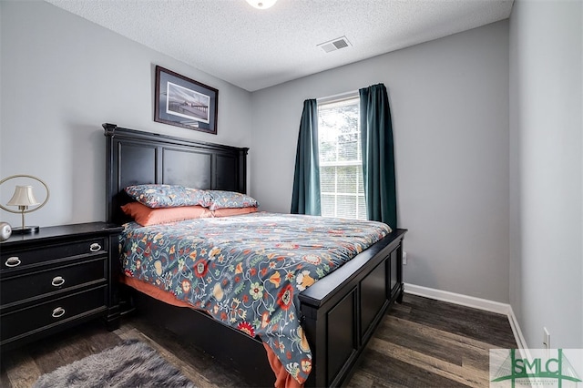 bedroom featuring a textured ceiling and dark hardwood / wood-style floors