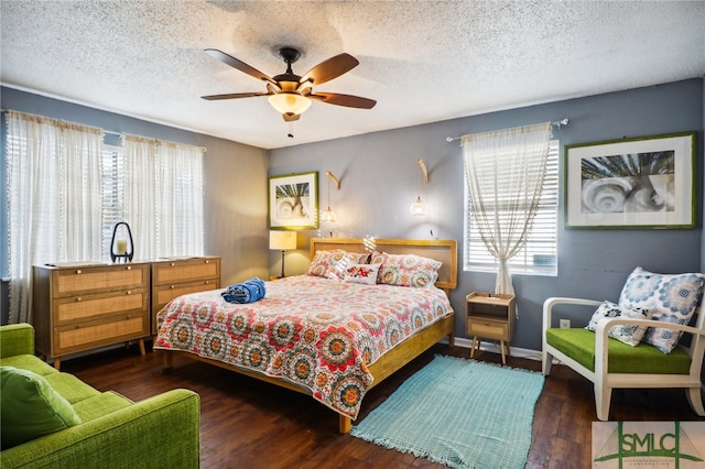 bedroom featuring multiple windows, a textured ceiling, dark hardwood / wood-style flooring, and ceiling fan