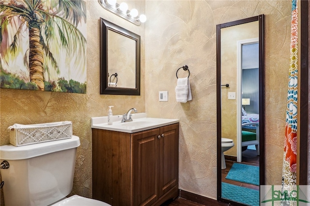 bathroom with vanity, wood-type flooring, and toilet