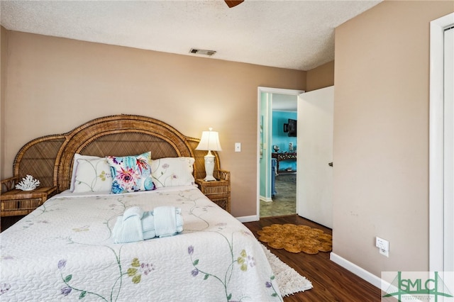 bedroom featuring a textured ceiling, ceiling fan, and dark wood-type flooring