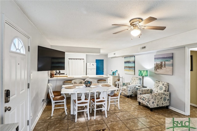 tiled dining area featuring ceiling fan and a textured ceiling