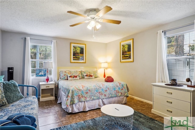 tiled bedroom featuring a textured ceiling and ceiling fan