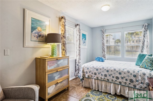 bedroom with light tile patterned floors and a textured ceiling