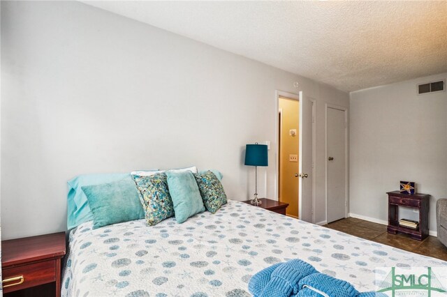 tiled bedroom featuring a textured ceiling