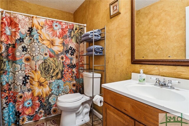 bathroom with vanity, a textured ceiling, and toilet