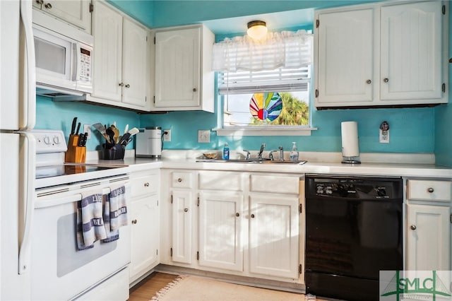 kitchen featuring sink, white cabinets, and white appliances