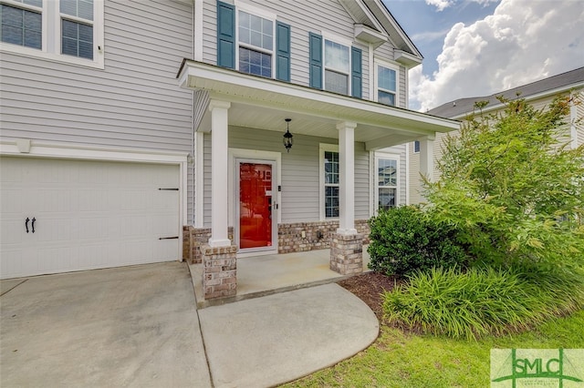 view of exterior entry with a porch and a garage