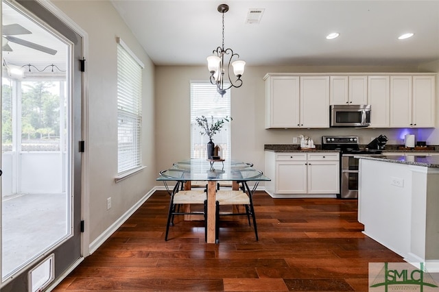 kitchen featuring white cabinetry, hanging light fixtures, dark wood-type flooring, and appliances with stainless steel finishes