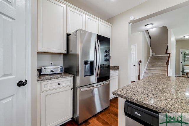 kitchen featuring light stone countertops, white cabinetry, dark wood-type flooring, and appliances with stainless steel finishes