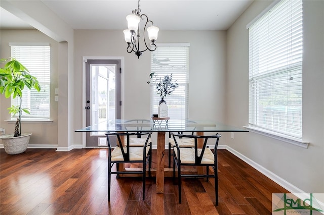 dining room featuring an inviting chandelier and dark wood-type flooring