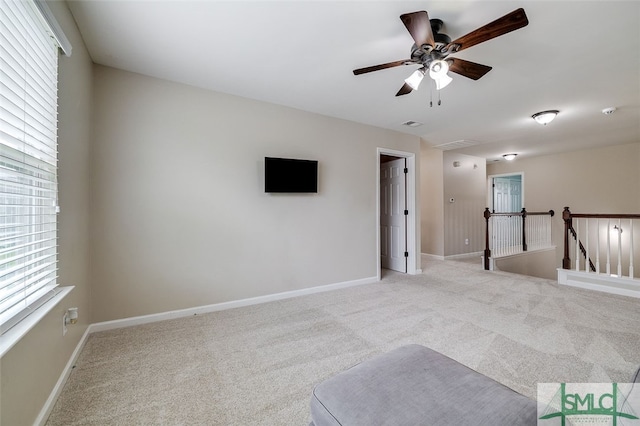 carpeted spare room with ceiling fan