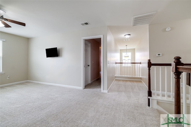 carpeted spare room featuring a chandelier