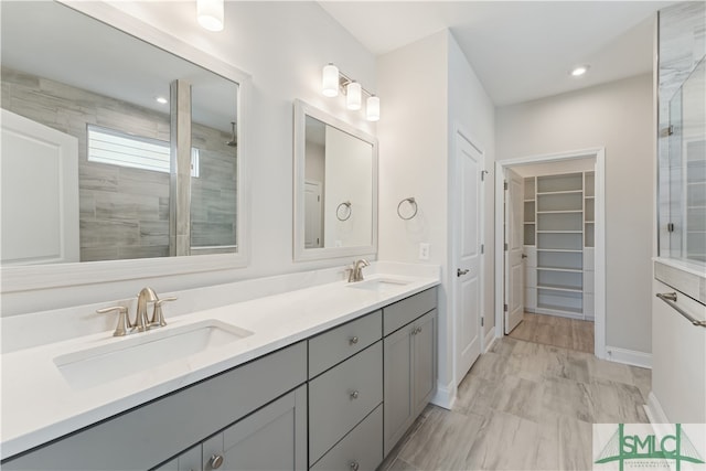 bathroom featuring a tile shower and vanity