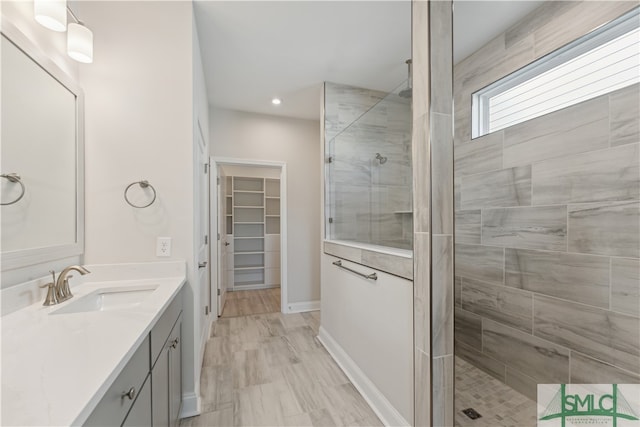 bathroom featuring a tile shower and vanity