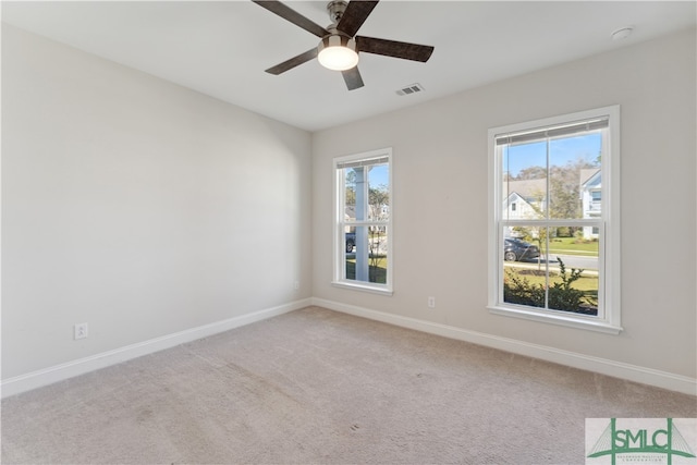 spare room with ceiling fan and light colored carpet